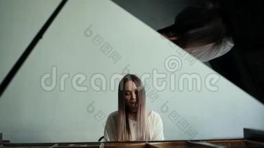 女钢琴家在墙上慢动作的背景下弹奏钢琴音乐